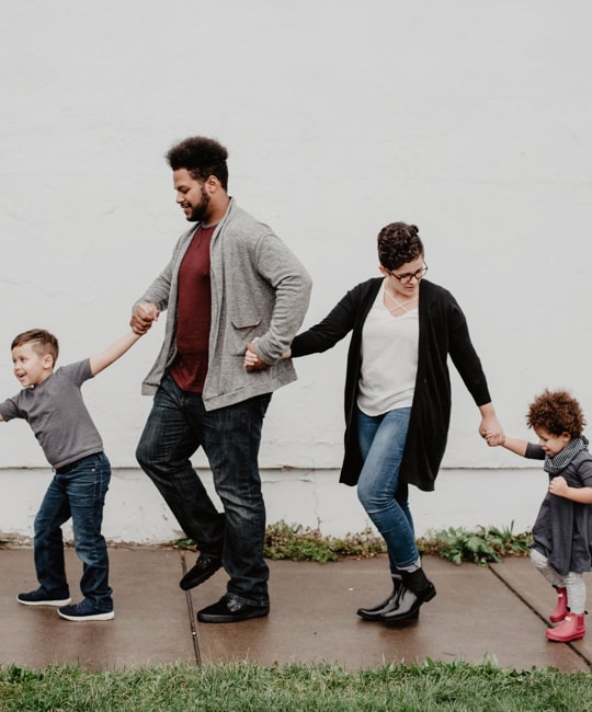 parent holding hands with their 2 children